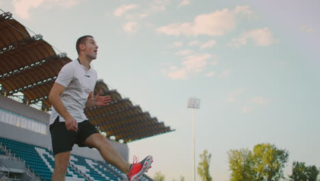 Hochkippen-Mit-Zeitlupe-Eines-Mannes-Aus-Der-Profi-Fußballliga,-Der-An-Einem-Sonnigen-Sommertag-Auf-Dem-Spielfeld-Im-Freien-Mit-Dem-Ball-Am-Bein-Jongliert